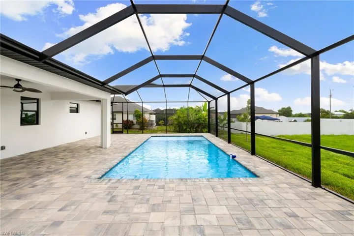 View of swimming pool with a patio area, ceiling fan, and a lanai