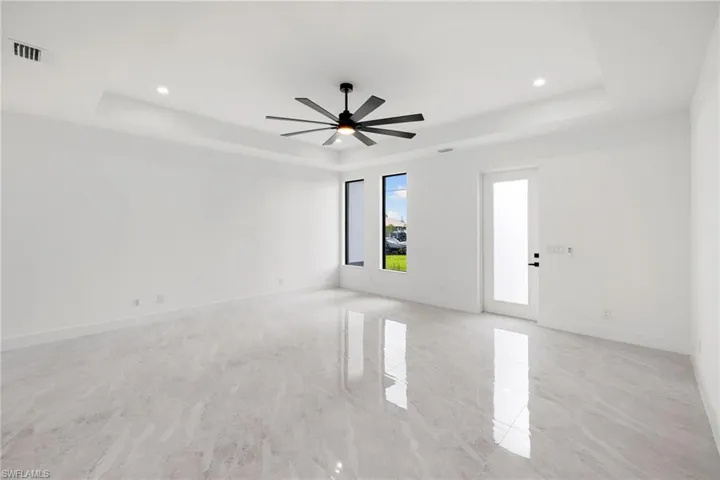 Unfurnished room with a tray ceiling, recessed lighting, and ceiling fan