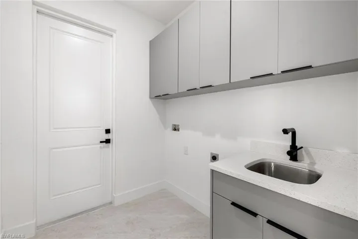 Laundry room with electric dryer hookup, hookup for a washing machine, and cabinet space
