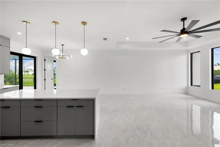 Kitchen featuring gray cabinets, modern cabinets, plenty of natural light, light countertops, and recessed lighting