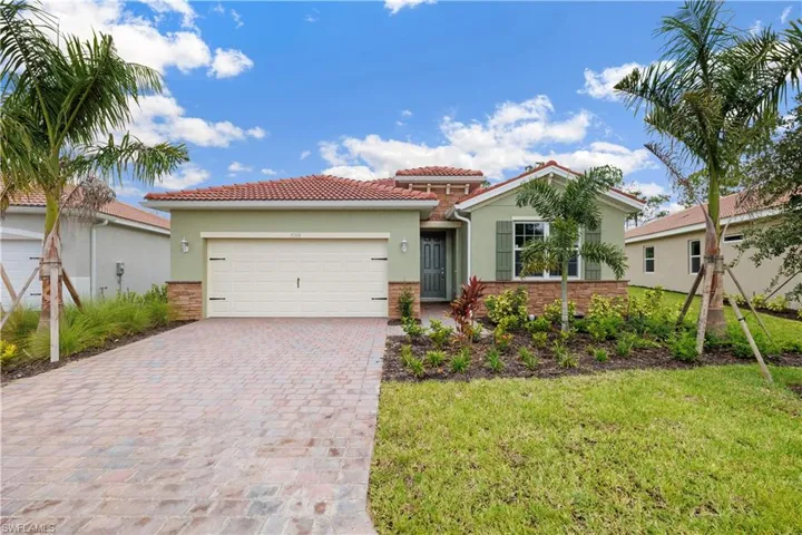 Mediterranean / spanish-style home featuring a garage and a front lawn