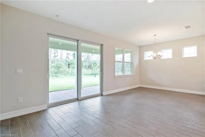 Spare room featuring light hardwood / wood-style floors and an inviting chandelier