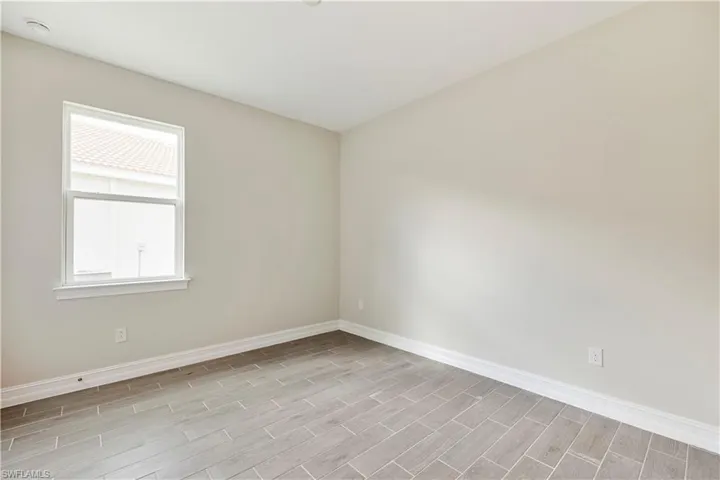 Empty room with light hardwood / wood-style floors and a wealth of natural light