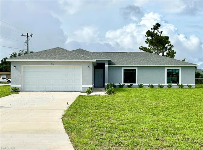 Ranch-style home featuring a garage and a front yard