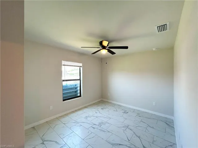 Tiled empty room with ceiling fan
