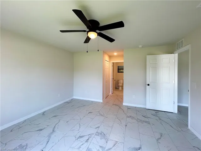 Unfurnished bedroom with ceiling fan, a closet, ensuite bath, and light tile floors