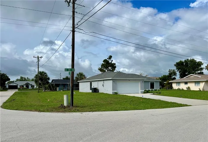Single story home featuring a front yard and a garage