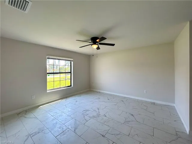 Tiled empty room with ceiling fan
