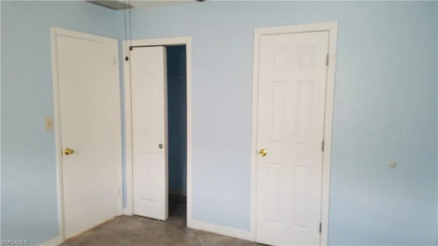 Unfurnished bedroom featuring a closet and dark carpet