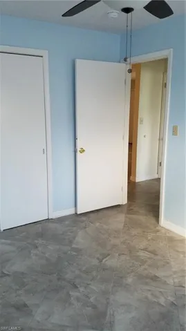 Unfurnished bedroom with ceiling fan and baseboards