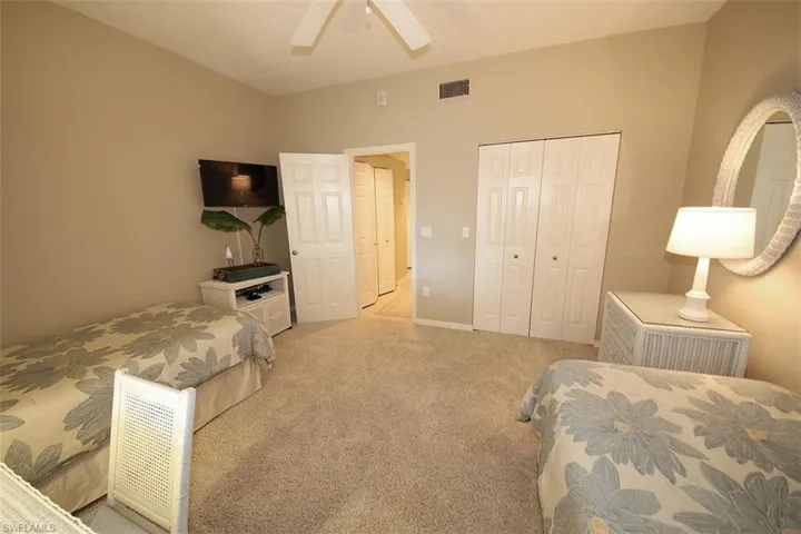 Carpeted bedroom featuring a closet and a ceiling fan