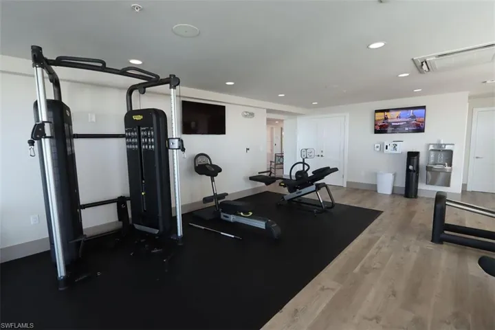 Workout room with recessed lighting, light wood-style flooring, and attic access