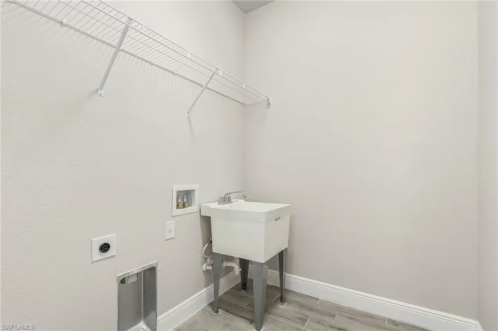 Washroom featuring electric dryer hookup, light wood-type flooring, and hookup for a washing machine Finishes may vary, pictures for illustration purposes only