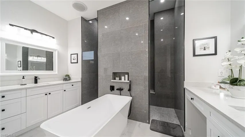 Bathroom with independent shower and bath, dual sinks, and large vanity