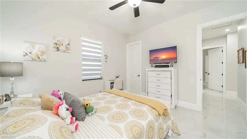 Bedroom with ceiling fan and light tile flooring
