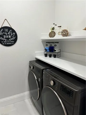 Laundry room featuring tile flooring and washing machine and clothes dryer
