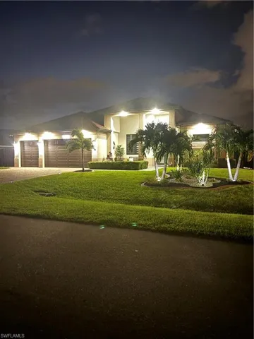 View of front of property featuring a garage and a lawn