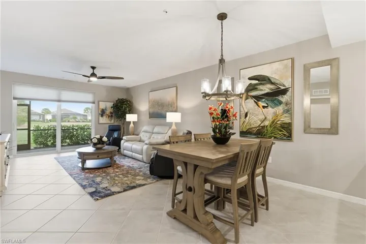 Dining room featuring a ceiling fan, a chandelier, and light tile patterned floors