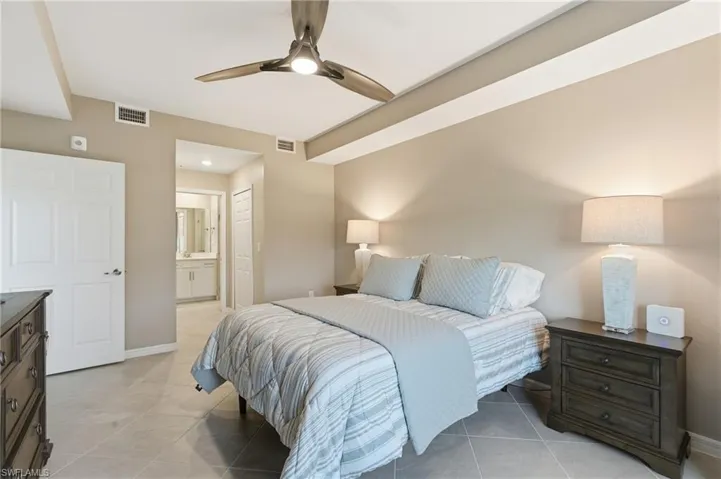 Main Bedroom featuring ensuite bath, ceiling fan, and light tile patterned floors