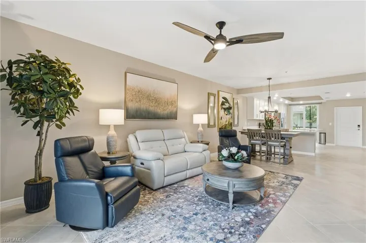 Living room with a ceiling fan and light tile patterned floors