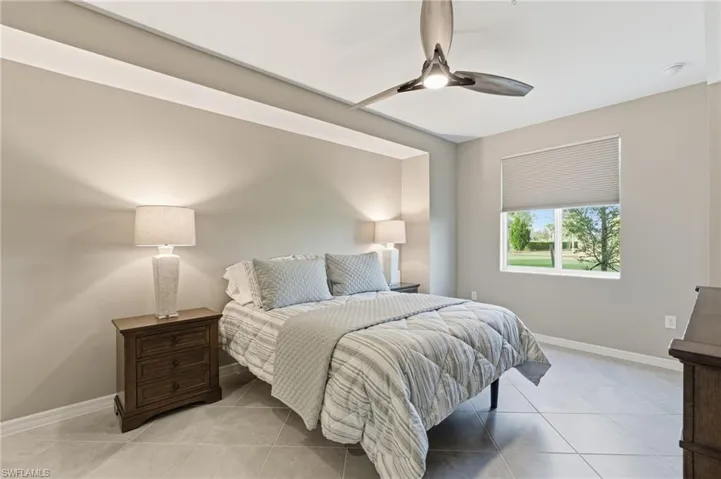 Bedroom with ceiling fan and light tile patterned floors