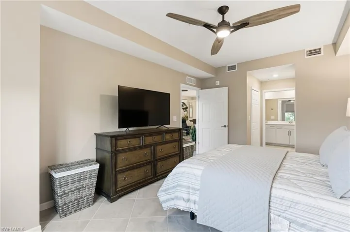 Nain Bedroom featuring connected bathroom, a ceiling fan, and light tile patterned floors