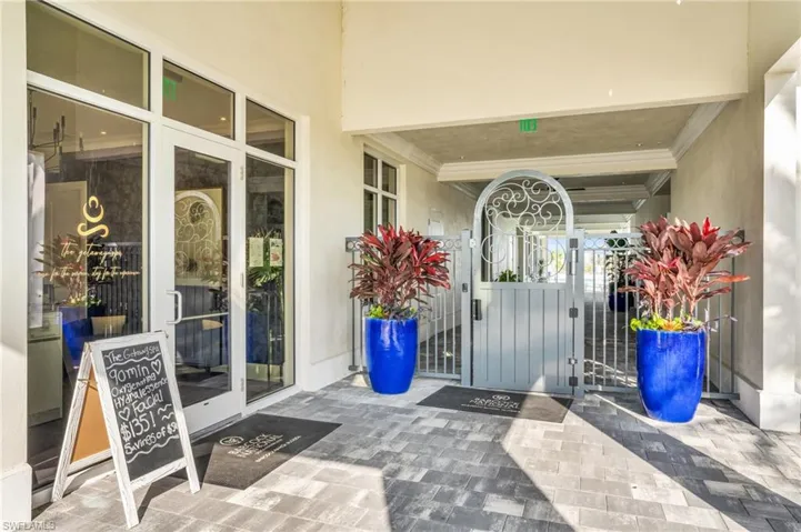 View of exterior entry featuring a gate and stucco siding