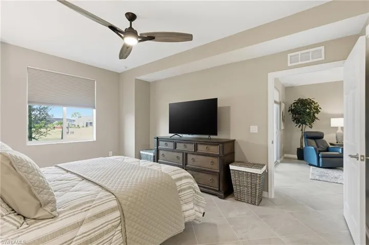 Tiled bedroom with ceiling fan and baseboards