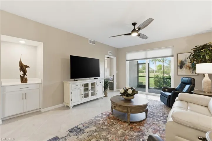 Living room with ceiling fan and light tile patterned floors