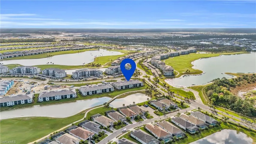 Aerial view of residential area featuring a large body of water and a golf club