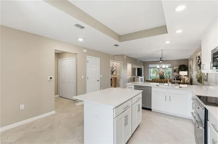 Kitchen featuring a peninsula, stainless steel appliances, white cabinetry, recessed lighting, and a kitchen island