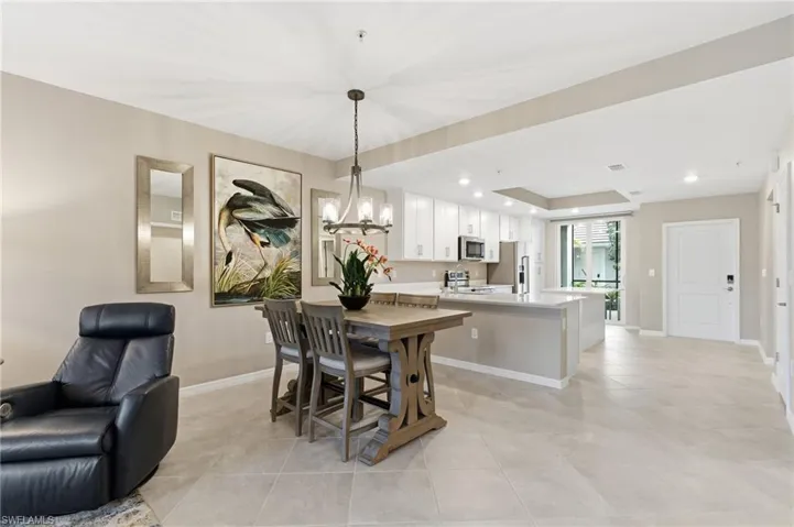 Dining area with recessed lighting, light tile patterned floors, a chandelier, and a raised ceiling