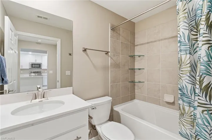 Bathroom with shower / bath combination with curtain and vanity