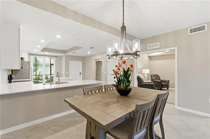 Dining area featuring a chandelier, a raised ceiling, and recessed lighting