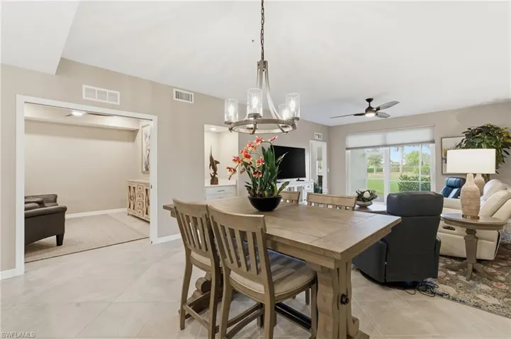 Dining space featuring a chandelier, ceiling fan, and light tile patterned flooring