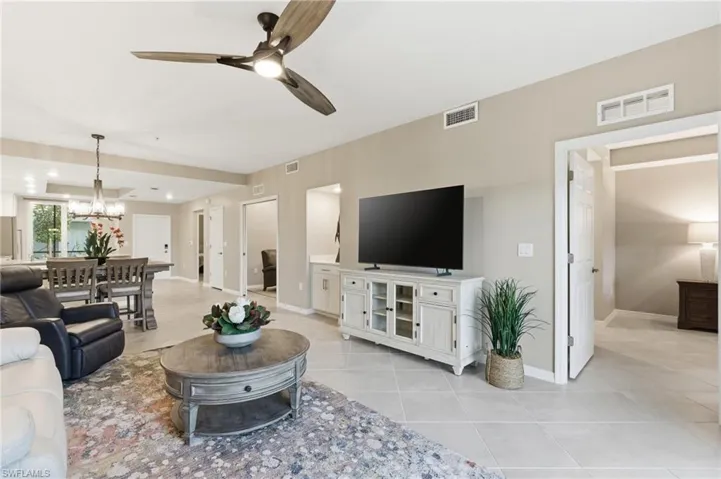 Living room featuring ceiling fan, light tile patterned floors, a chandelier, and recessed lighting