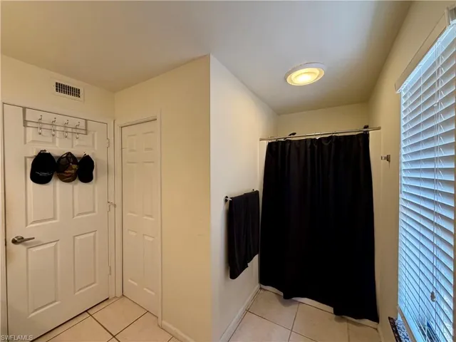Bathroom with light tile patterned flooring and a shower with curtain