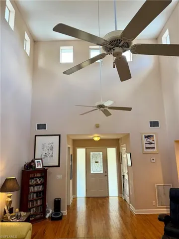 Entryway featuring light wood finished floors, a high ceiling, and a ceiling fan