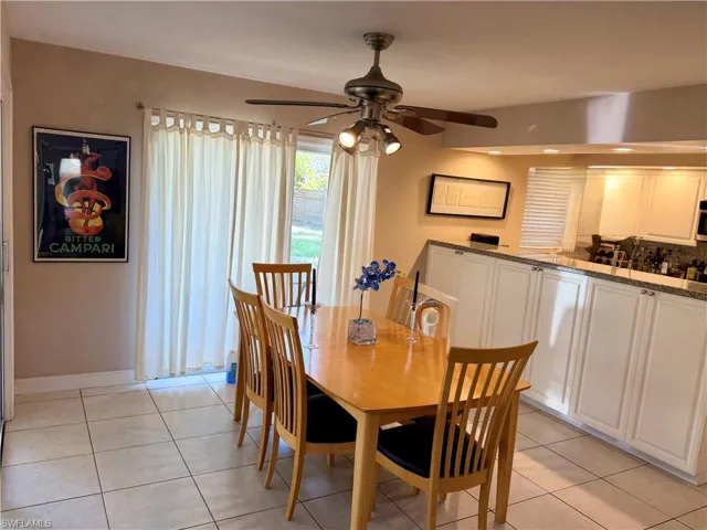 Dining area with light tile patterned floors and ceiling fan