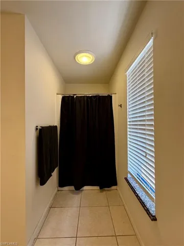 Bathroom featuring light tile patterned flooring and a shower with shower curtain