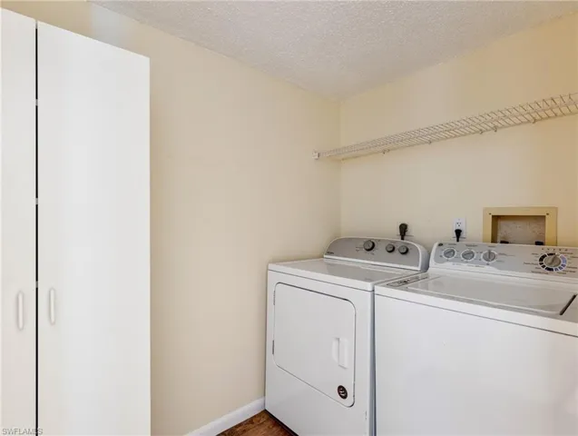Laundry featuring washing machine and dryer and a textured ceiling