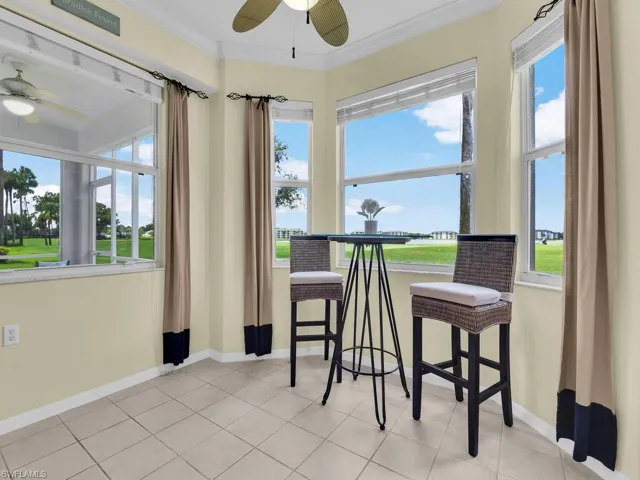 Tiled dining area with a ceiling fan and ornamental molding
