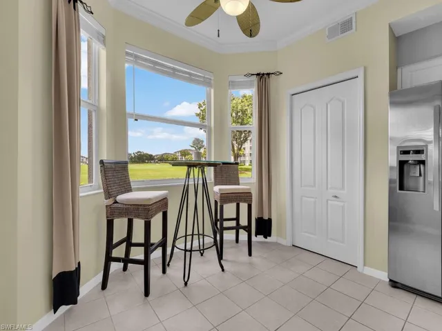 Dining area featuring a ceiling fan, crown molding, and light tile patterned floors