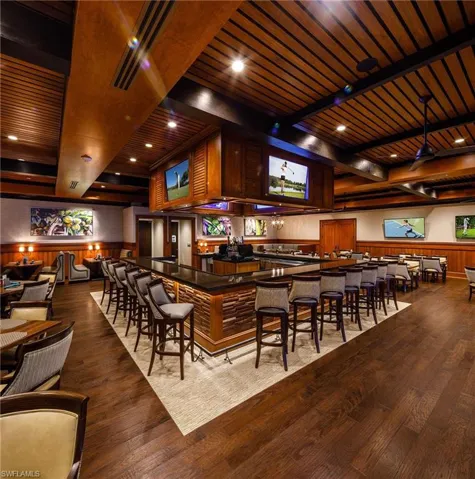 Bar featuring a wainscoted wall, wood finished floors, wood walls, and recessed lighting