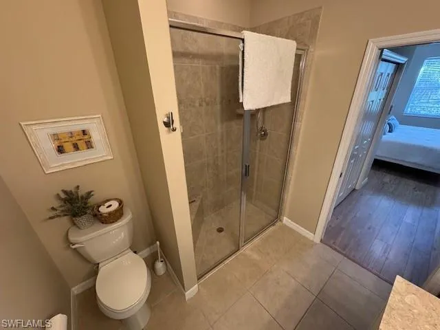Bathroom featuring a shower stall, ensuite bathroom, and tile patterned flooring