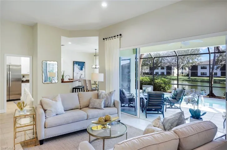 Great Room featuring serene lake views and private pool with mood-setting firepit on covered lanai!