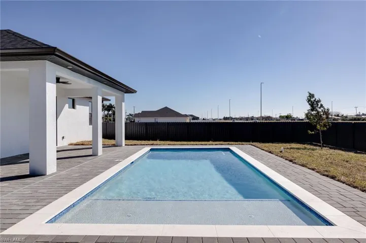View of pool featuring patio surround and a fenced backyard