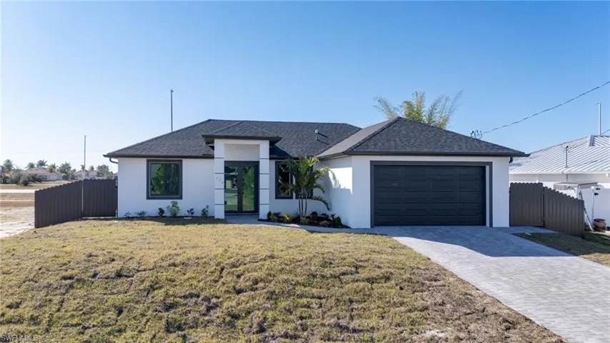 Ranch-style house featuring stucco siding and a paver driveway