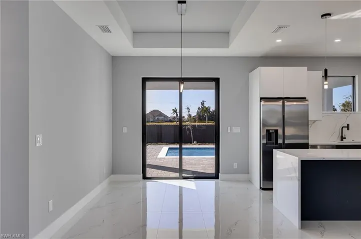 Dining area featuring a tray ceiling and modern lighting.
