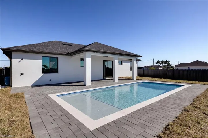 View of swimming pool featuring patio surround and a fenced backyard